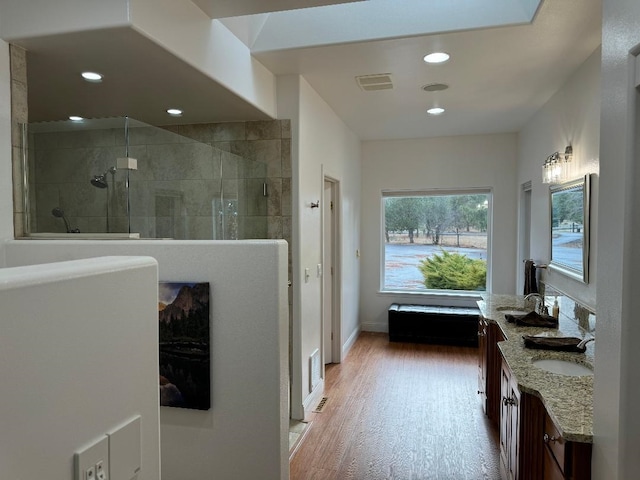 bathroom with vanity, wood finished floors, recessed lighting, and a walk in shower