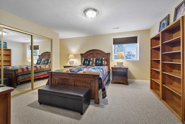 carpeted bedroom with multiple windows, a textured ceiling, and a closet