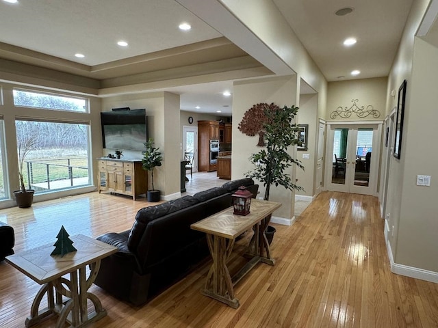 living area featuring baseboards, light wood-type flooring, and recessed lighting