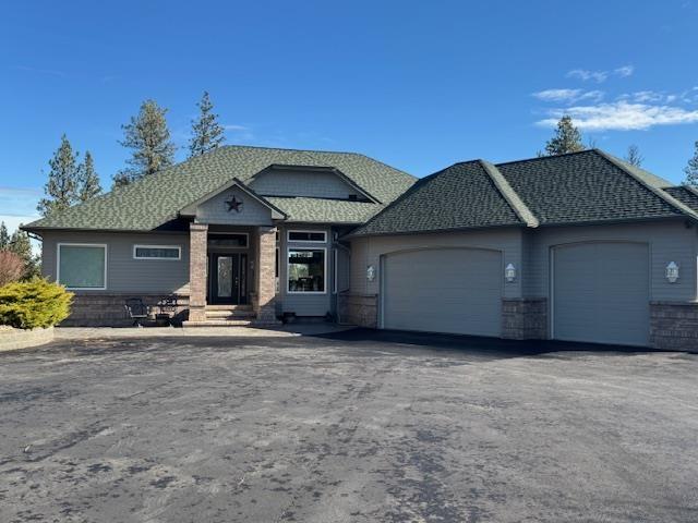 6919 E Spangle-Waverly Rd, Spangle, WA 99031 - view of front of property featuring an attached garage, asphalt driveway, entry steps, and roof with shingles