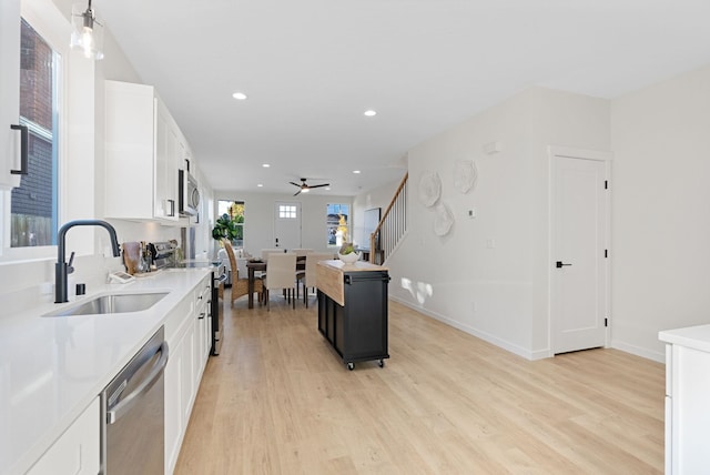 kitchen featuring white cabinetry, sink, a kitchen island, and appliances with stainless steel finishes