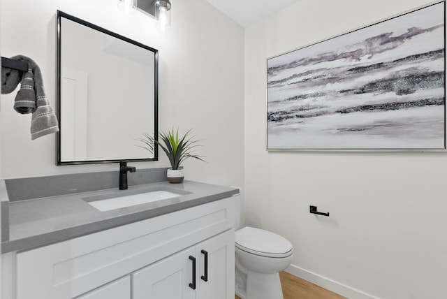 bathroom featuring hardwood / wood-style flooring, vanity, and toilet