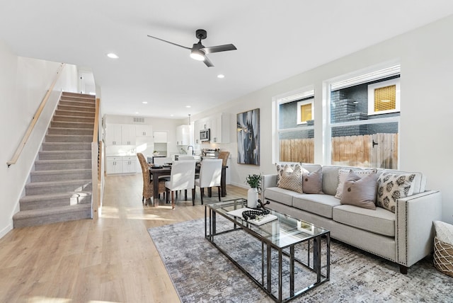 living room with ceiling fan and light hardwood / wood-style floors