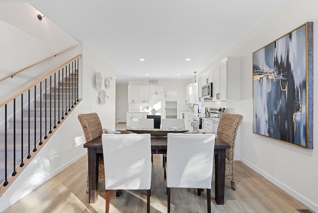 dining area featuring sink and light hardwood / wood-style flooring