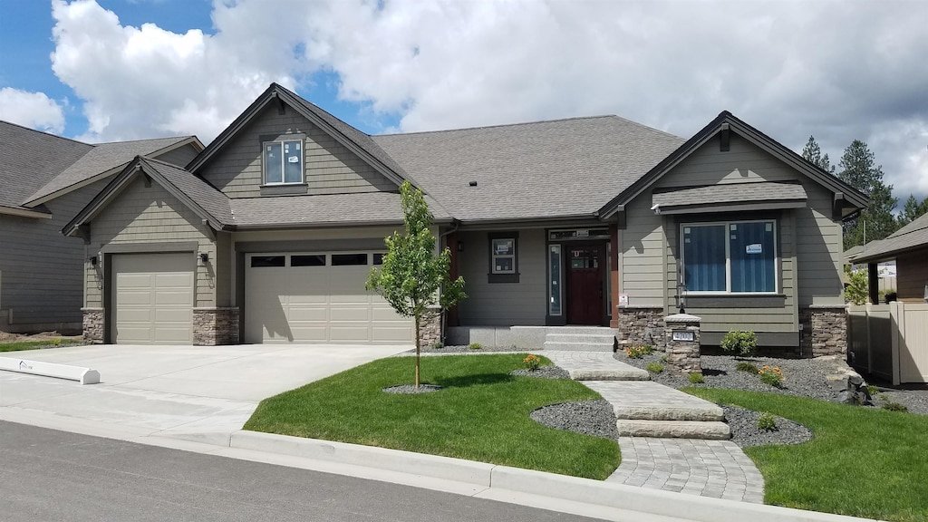 craftsman-style home featuring a garage and a front yard