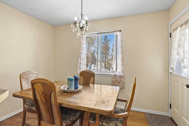 dining area featuring an inviting chandelier and hardwood / wood-style floors