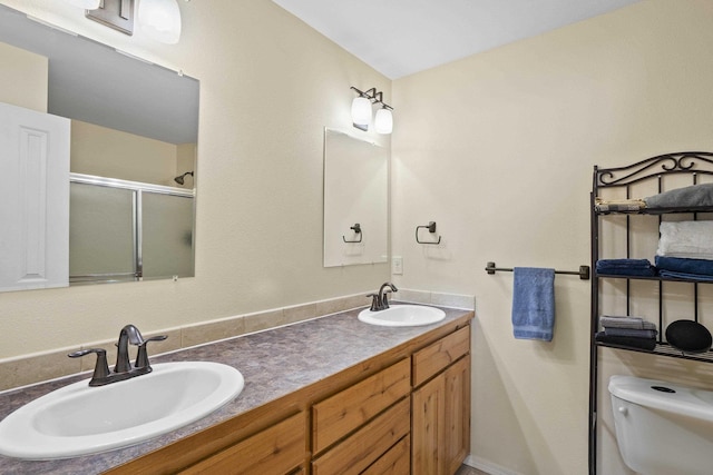 bathroom with walk in shower, vanity, and toilet