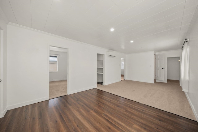 spare room featuring crown molding, a wall mounted air conditioner, and hardwood / wood-style flooring