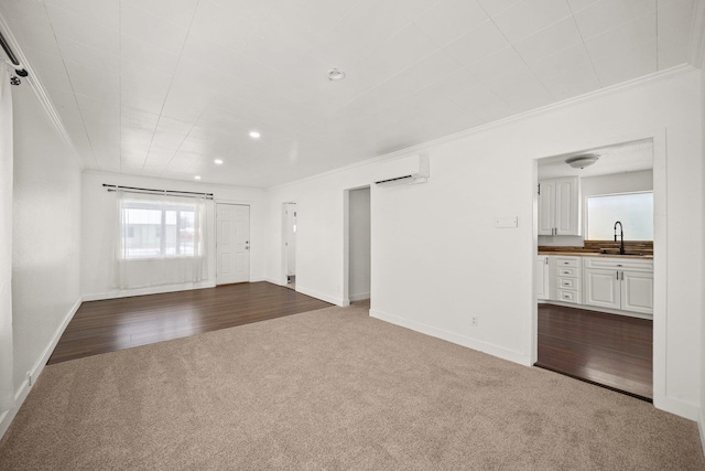 unfurnished living room featuring sink, crown molding, carpet floors, and a wall unit AC