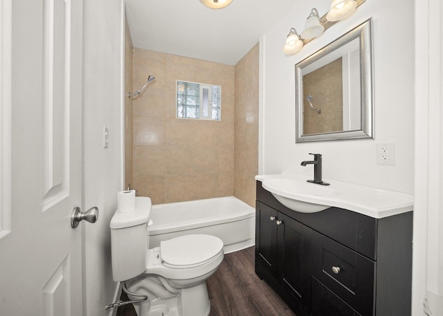 full bathroom with tiled shower / bath, vanity, toilet, and hardwood / wood-style floors