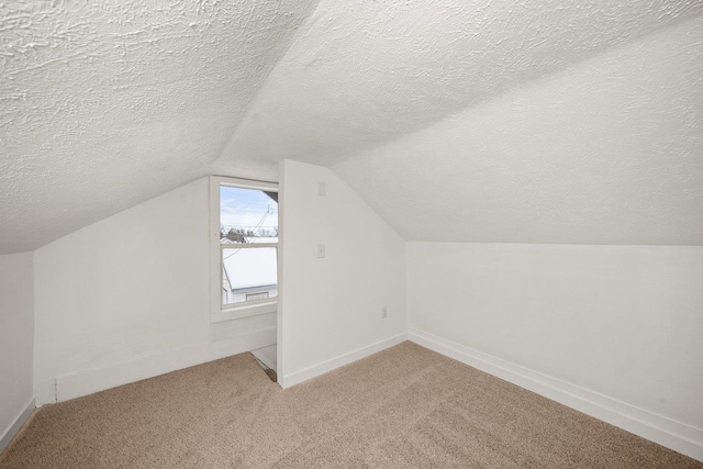 bonus room with carpet floors, a textured ceiling, and vaulted ceiling