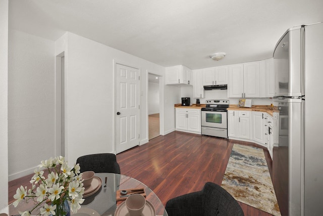 kitchen with white cabinetry, wood counters, stainless steel appliances, and dark hardwood / wood-style flooring