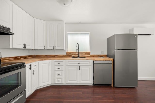 kitchen with sink, a wall mounted AC, appliances with stainless steel finishes, dark hardwood / wood-style floors, and white cabinets