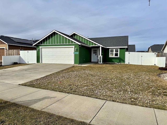 view of front facade with a gate, fence, board and batten siding, concrete driveway, and a garage