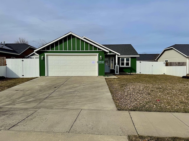 view of front of property featuring fence, concrete driveway, an attached garage, and a gate