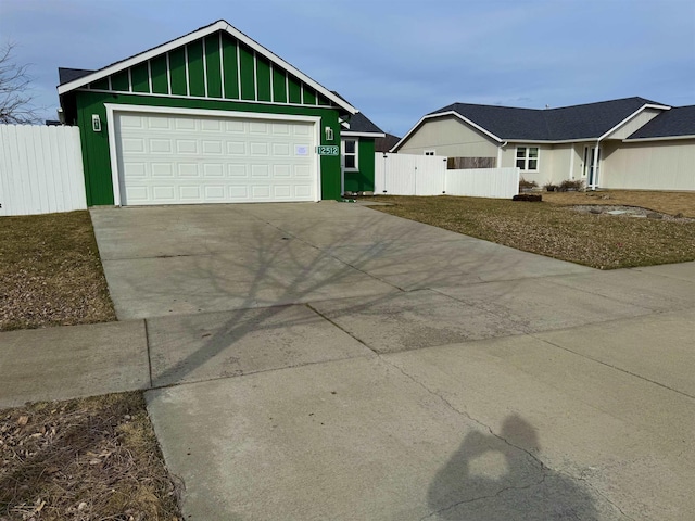 view of front facade featuring driveway, a garage, and fence