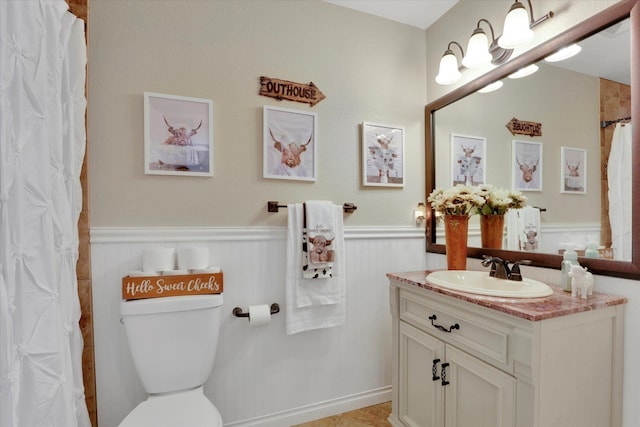 bathroom featuring vanity, curtained shower, and toilet