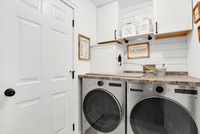 washroom featuring washer and clothes dryer and cabinets