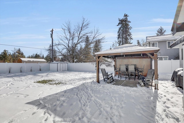 snowy yard featuring a storage unit