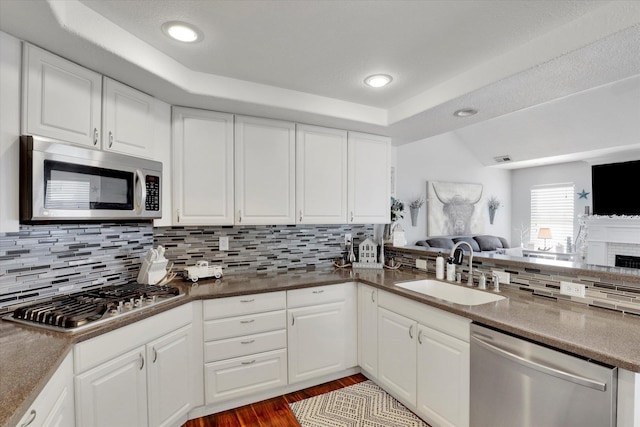 kitchen with white cabinetry, stainless steel appliances, sink, and decorative backsplash