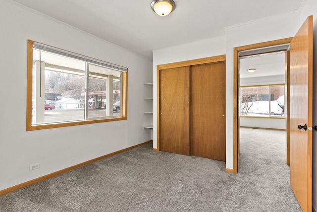 unfurnished bedroom featuring crown molding, carpet flooring, and a closet