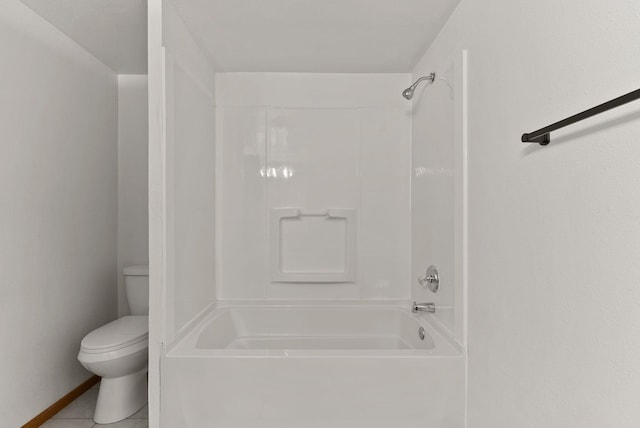 bathroom featuring bathing tub / shower combination, tile patterned floors, and toilet