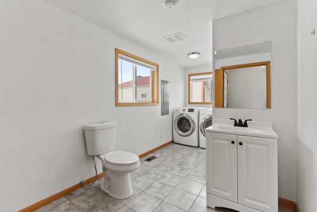 clothes washing area featuring sink, light tile patterned floors, electric panel, and independent washer and dryer