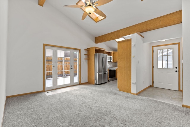 unfurnished living room with french doors, high vaulted ceiling, light carpet, ceiling fan, and beam ceiling