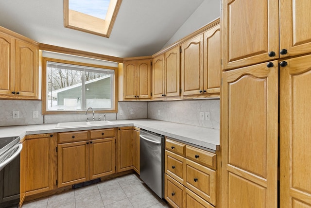 kitchen featuring light tile patterned flooring, lofted ceiling, sink, tasteful backsplash, and appliances with stainless steel finishes