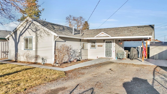 rear view of property featuring a shingled roof