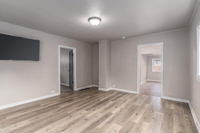 empty room featuring ornamental molding and light hardwood / wood-style floors