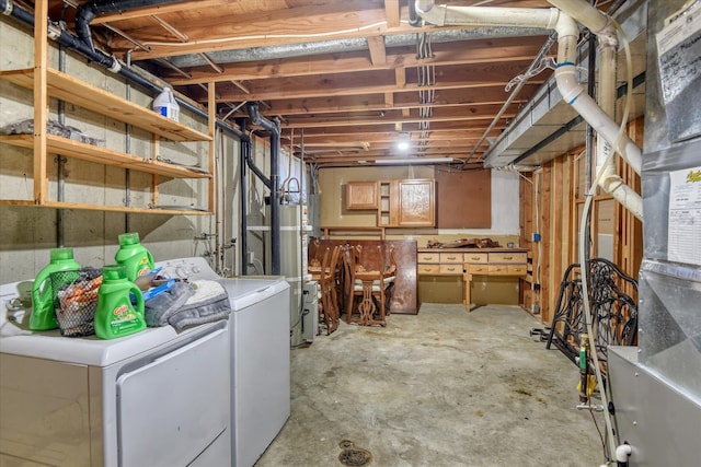 basement featuring gas water heater, heating unit, and washer and clothes dryer