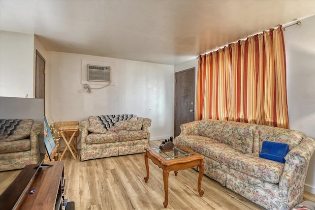 living room with a wall mounted AC and light wood-type flooring