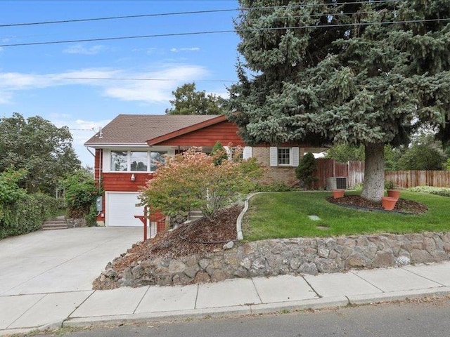 view of front of home with central AC, a garage, and a front lawn