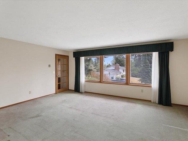 spare room featuring light colored carpet