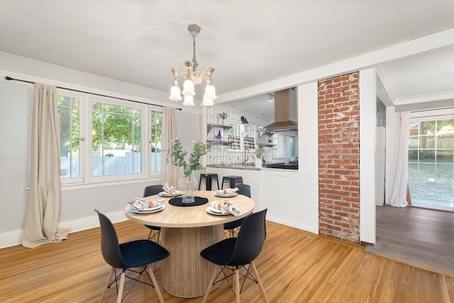 dining space with light wood-style flooring, an inviting chandelier, and baseboards