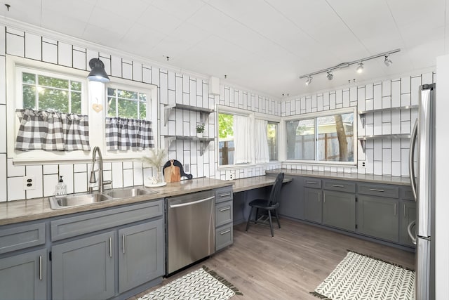 kitchen featuring a sink, gray cabinets, rail lighting, and stainless steel appliances