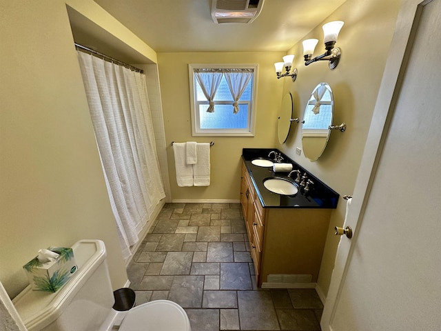 full bathroom featuring a sink, toilet, stone tile floors, baseboards, and visible vents