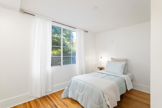 bedroom with wood finished floors and baseboards