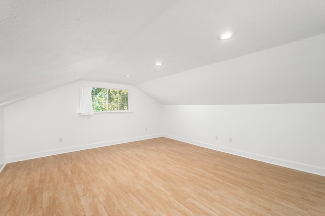 bonus room featuring lofted ceiling and light wood-type flooring