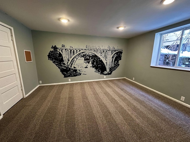 spare room with dark carpet and baseboards