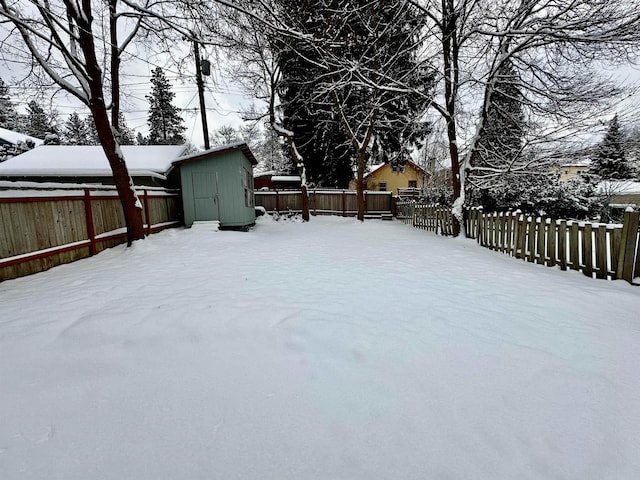 yard layered in snow with a storage unit