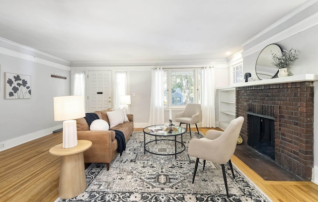 living room with crown molding, wood-type flooring, and a fireplace