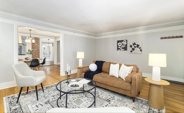 living room with crown molding, wood-type flooring, and a chandelier