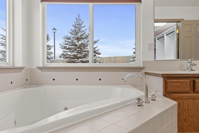 bathroom featuring tiled tub and vanity