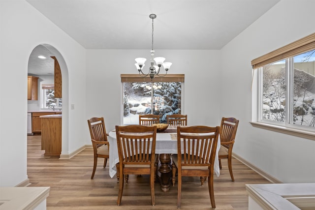 dining area with an inviting chandelier, sink, plenty of natural light, and light hardwood / wood-style floors