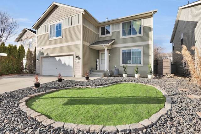 view of front of home featuring concrete driveway, board and batten siding, a front yard, fence, and a garage