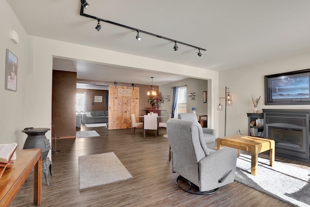 living room with dark wood-type flooring and a barn door