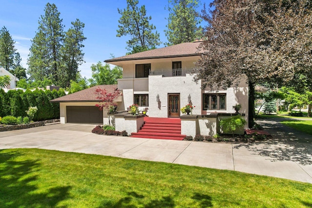 view of front of home featuring a balcony, a garage, and a front yard