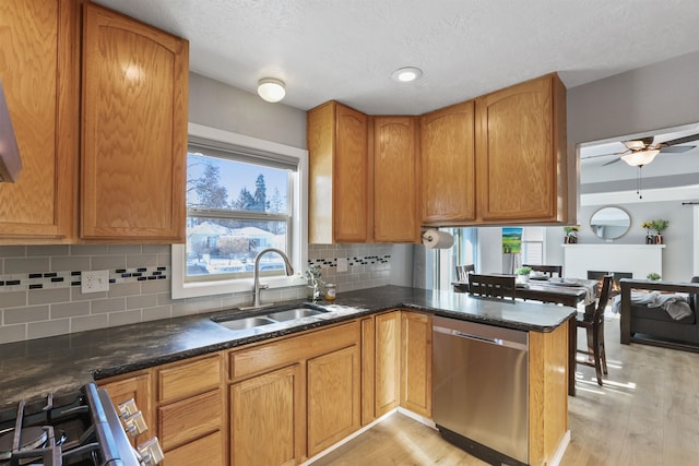 kitchen with sink, light hardwood / wood-style flooring, backsplash, stainless steel appliances, and kitchen peninsula